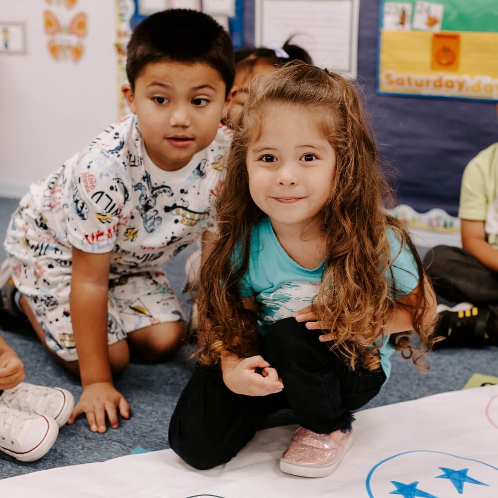 Two children engaged in a classroom activity, highlighting collaboration and early childhood education.