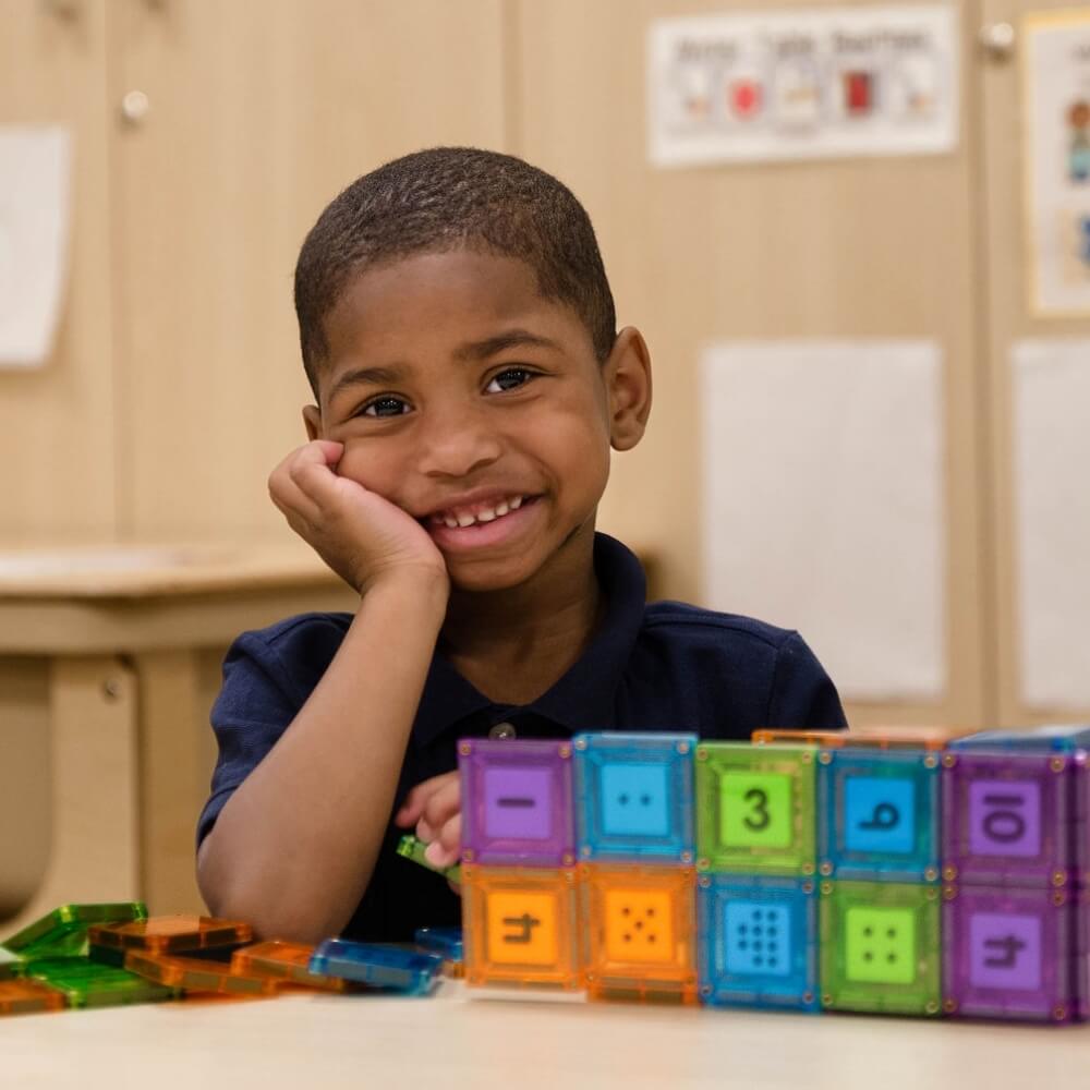 Children playing with colorful blocks in a classroom setting, fostering creativity and learning.