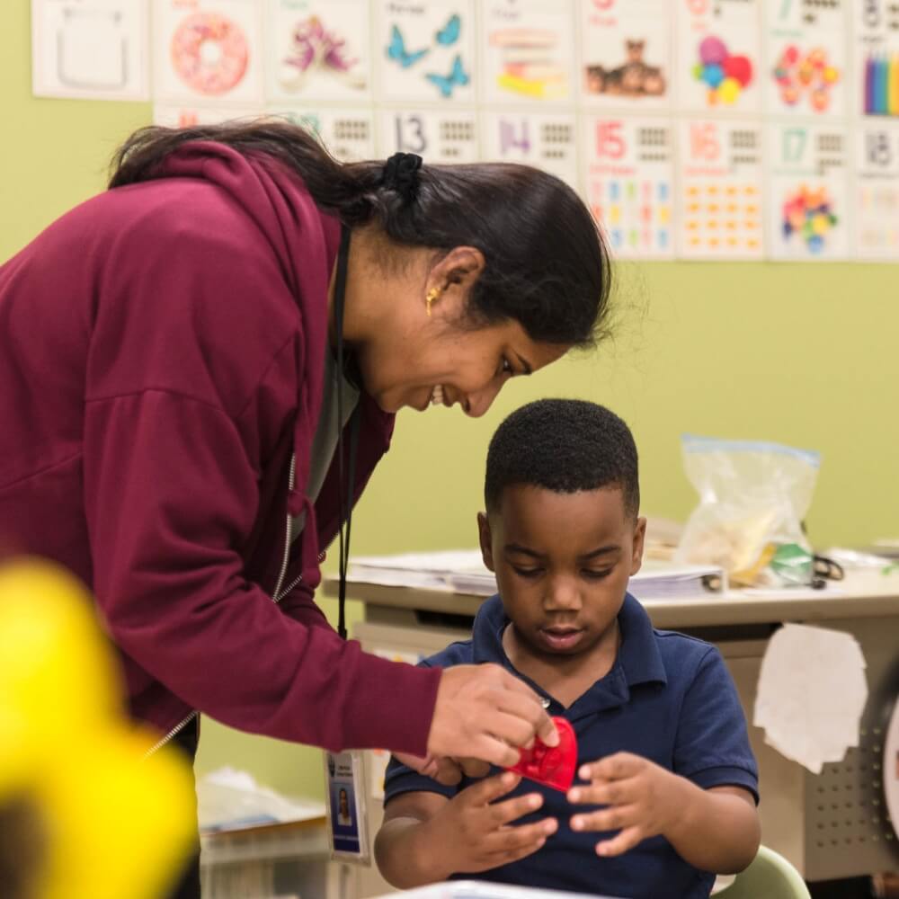 Teacher interacting with a student, highlighting personalized education.