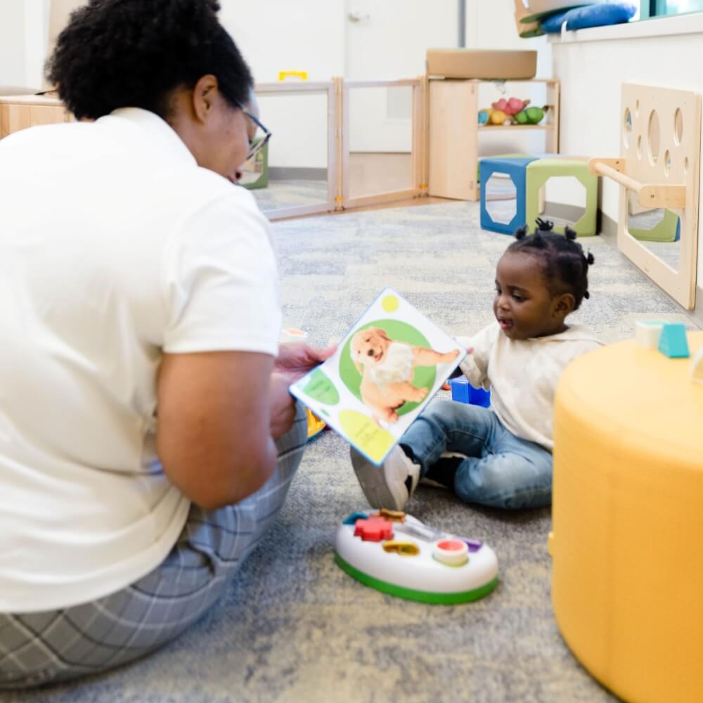 Teacher reading to an infant, fostering early literacy.