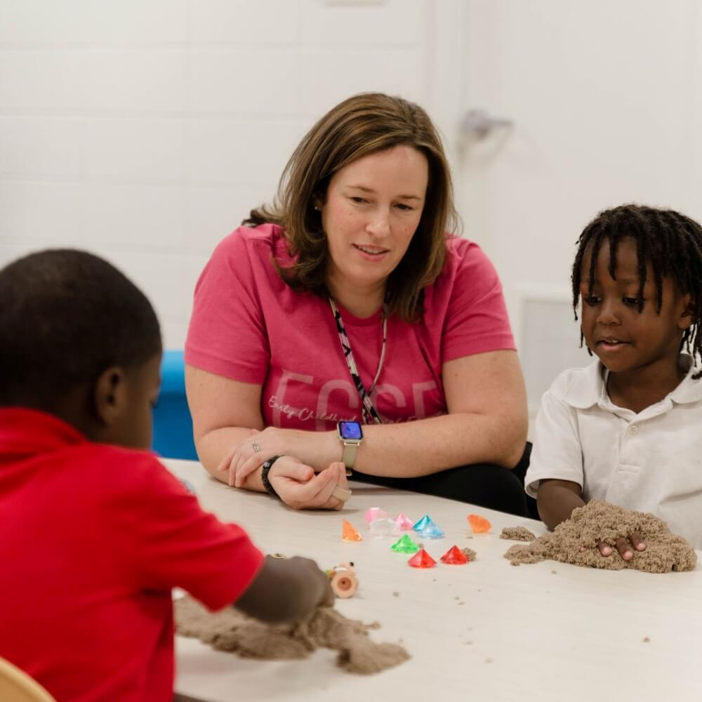 Teacher facilitating sensory play, promoting development through exploration.